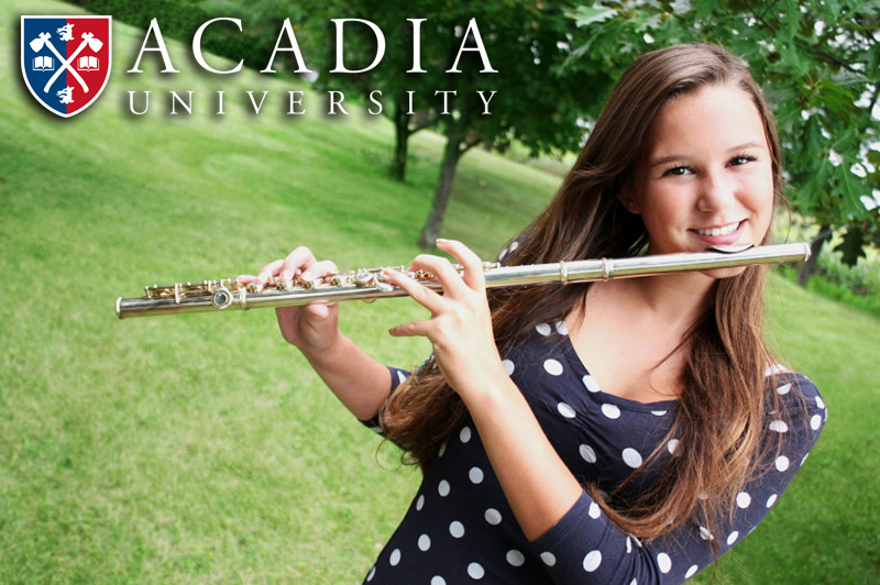 A smiling young woman plays the flute in front of trees in the summertime. The next summer music academy will take place July 3-9, 2022.